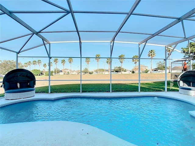 view of swimming pool with a lawn and glass enclosure