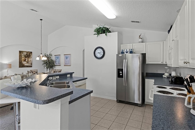 kitchen featuring white cabinets, white appliances, lofted ceiling, and a breakfast bar