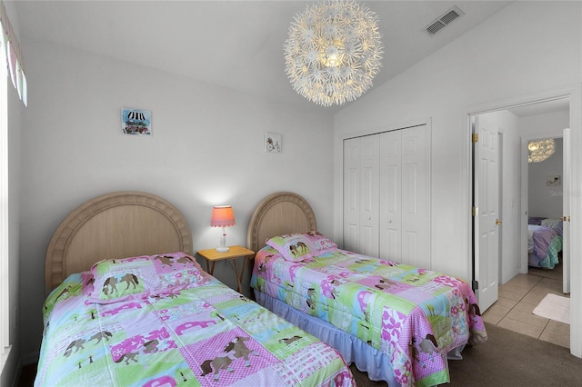 bedroom featuring a notable chandelier, vaulted ceiling, light tile patterned floors, and a closet