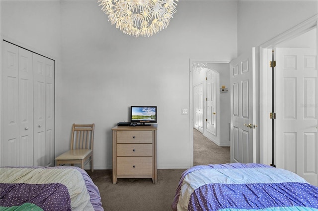 carpeted bedroom with a closet, a high ceiling, and an inviting chandelier