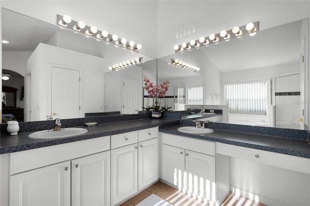 bathroom featuring vanity, lofted ceiling, a shower with door, tile patterned floors, and ceiling fan