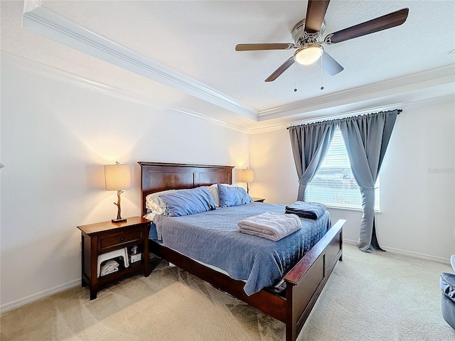 carpeted bedroom with a tray ceiling, ceiling fan, and ornamental molding