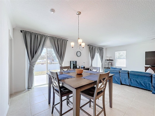 tiled dining room with a textured ceiling and an inviting chandelier