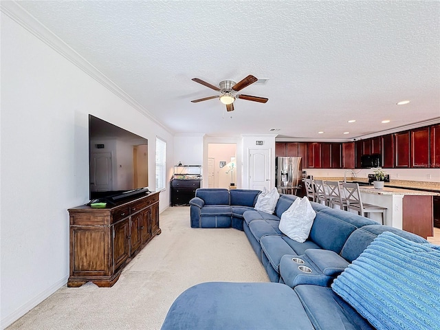 living room featuring a textured ceiling, ceiling fan, and crown molding