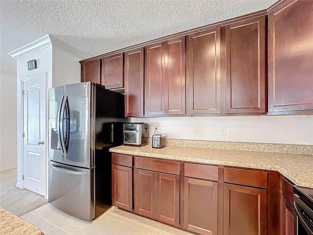 kitchen with stove, stainless steel refrigerator with ice dispenser, ornamental molding, a textured ceiling, and light tile patterned floors