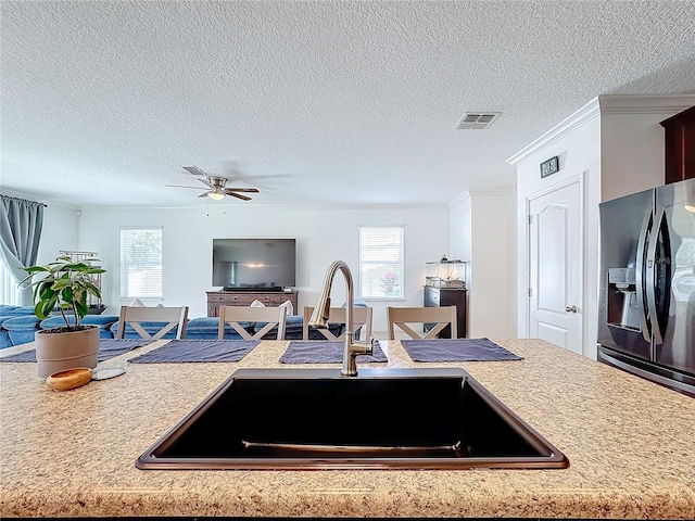 kitchen with plenty of natural light, stainless steel fridge, sink, and ceiling fan