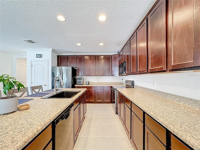 kitchen with a textured ceiling, stainless steel appliances, crown molding, sink, and light tile patterned flooring