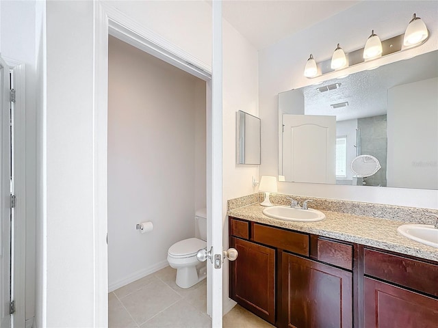 bathroom with tile patterned floors, vanity, toilet, and walk in shower