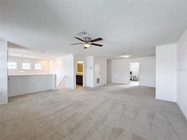 carpeted empty room with ceiling fan and a textured ceiling