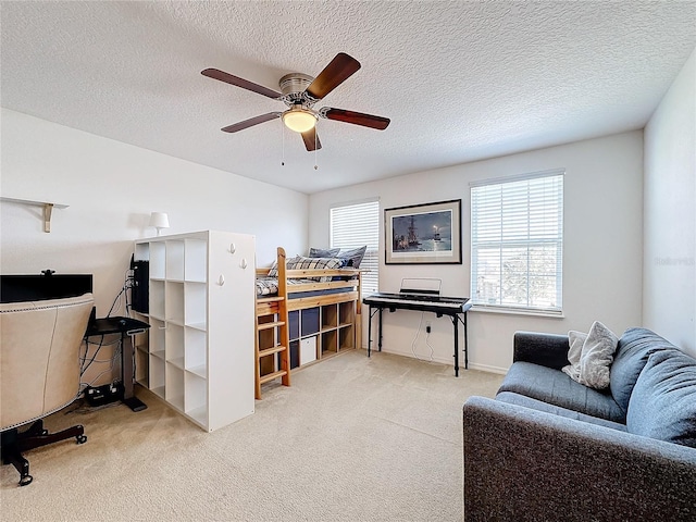 carpeted bedroom featuring ceiling fan and a textured ceiling