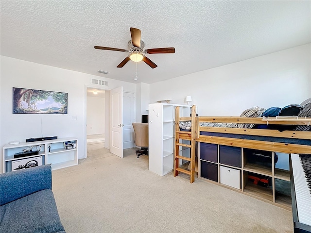 bedroom featuring carpet flooring, ceiling fan, and a textured ceiling