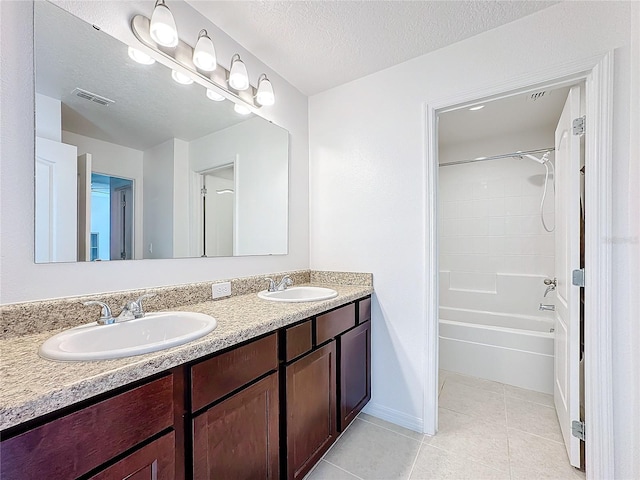 bathroom featuring tile patterned floors, shower / washtub combination, vanity, and a textured ceiling