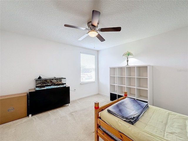 carpeted bedroom with ceiling fan and a textured ceiling