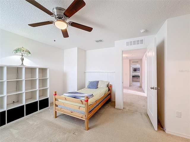 carpeted bedroom with a textured ceiling and ceiling fan