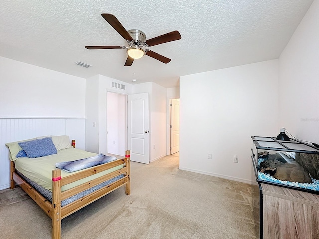 carpeted bedroom featuring a textured ceiling and ceiling fan