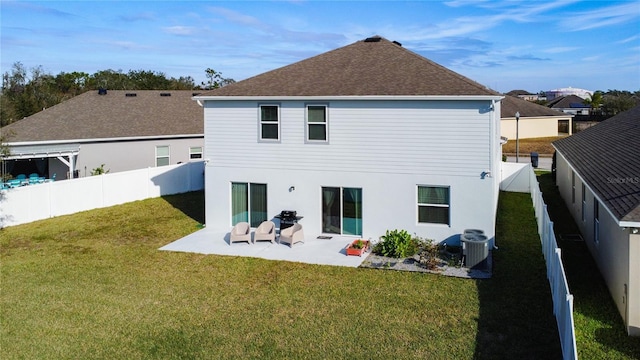 rear view of house with a lawn, cooling unit, and a patio area