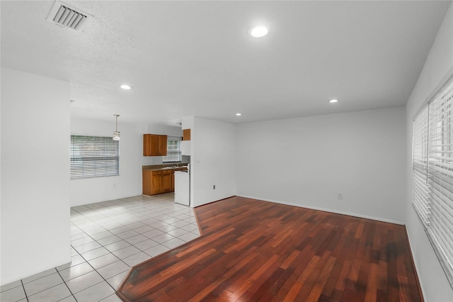 unfurnished living room with light tile patterned floors and a textured ceiling