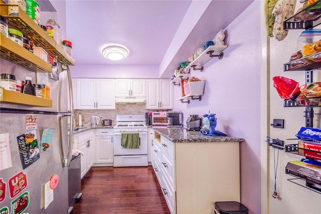 kitchen featuring stainless steel fridge, tasteful backsplash, dark stone countertops, white stove, and white cabinetry