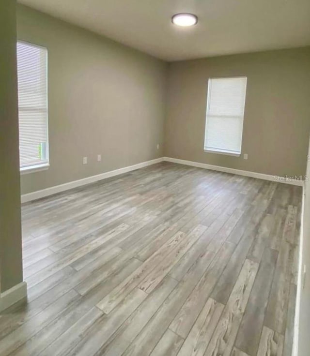 unfurnished room featuring a healthy amount of sunlight and light hardwood / wood-style flooring