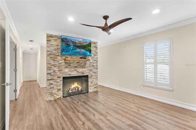 unfurnished living room with ceiling fan, ornamental molding, a fireplace, and light wood-type flooring