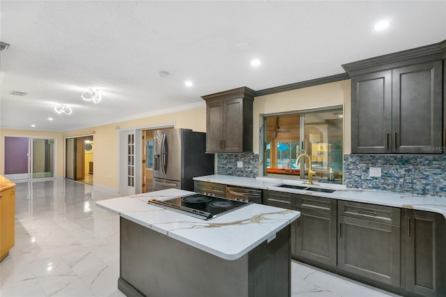 kitchen featuring sink, crown molding, a center island, appliances with stainless steel finishes, and backsplash