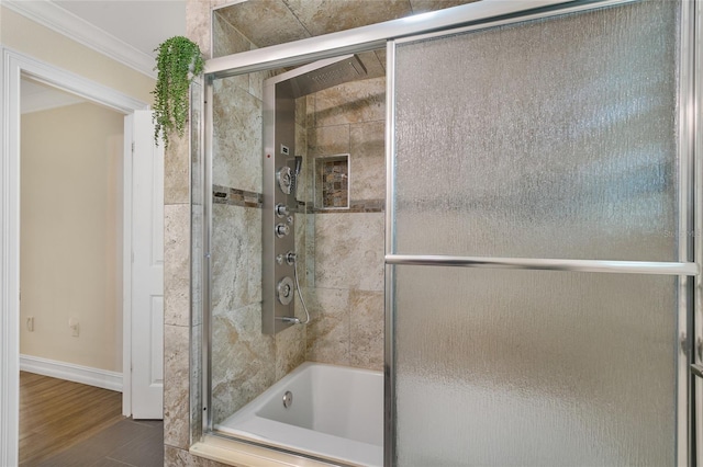 bathroom with hardwood / wood-style flooring, crown molding, and bath / shower combo with glass door