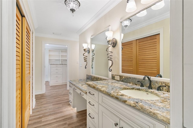 bathroom with hardwood / wood-style flooring, ornamental molding, and vanity