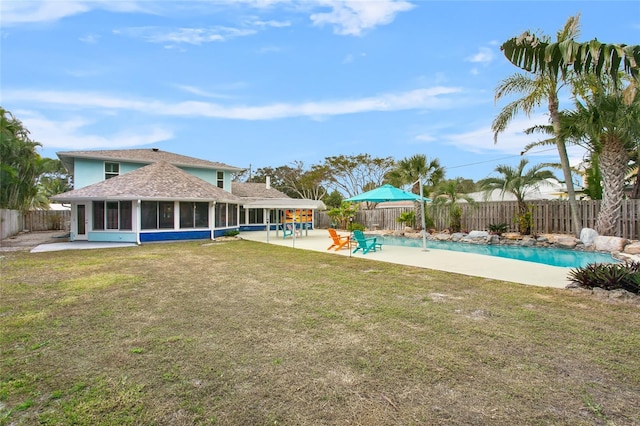 view of yard featuring a fenced in pool, a sunroom, and a patio area