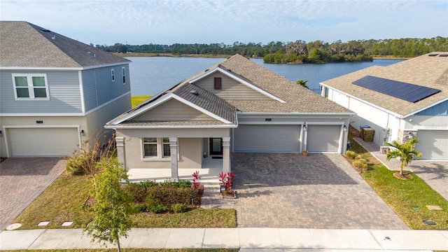 view of front of property with a water view, covered porch, and a garage