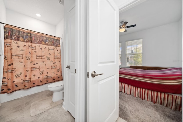 bathroom featuring toilet, shower / tub combo with curtain, and ceiling fan