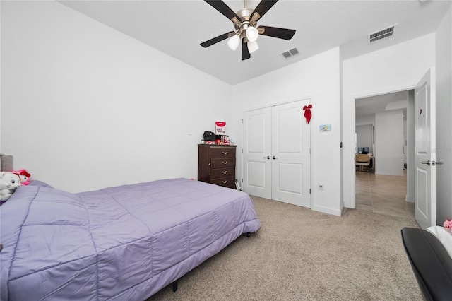 carpeted bedroom featuring ceiling fan and a closet