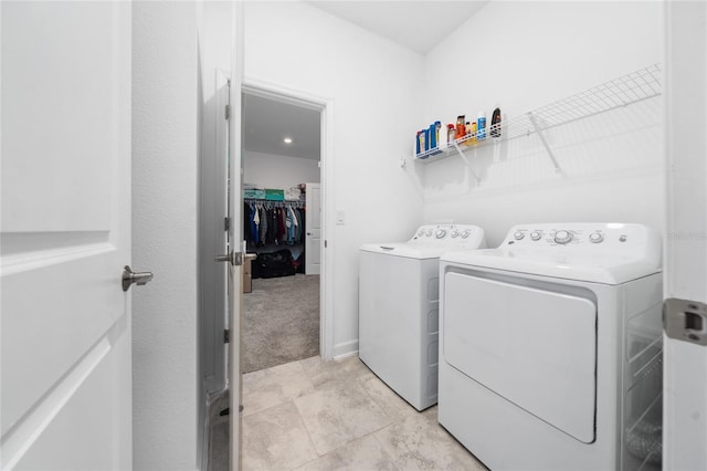 washroom with separate washer and dryer and light carpet