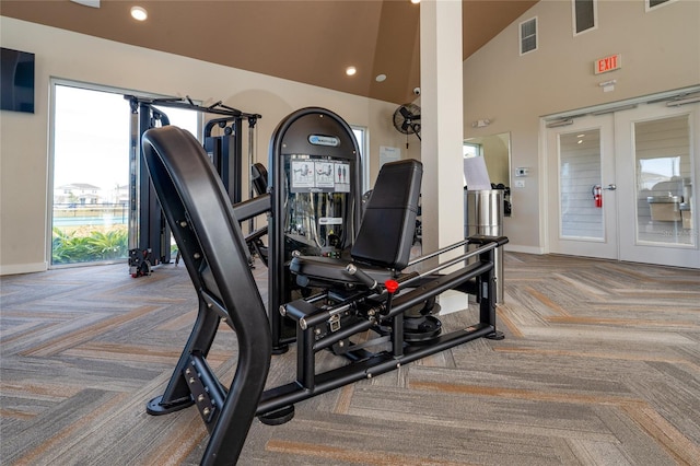 workout area with french doors, carpet floors, and high vaulted ceiling