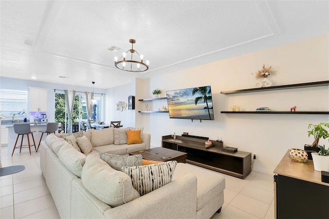 living room with light tile patterned flooring and an inviting chandelier