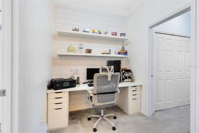 carpeted home office featuring wooden walls