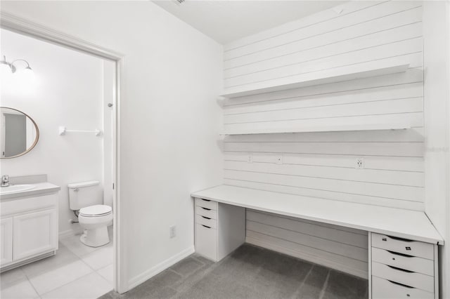 bathroom with baseboards, vanity, and toilet