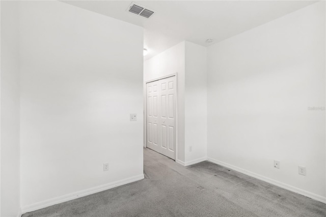 spare room with carpet, visible vents, and baseboards