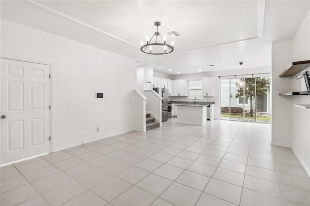 unfurnished living room featuring light tile patterned floors, recessed lighting, a sink, visible vents, and an inviting chandelier