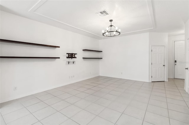 spare room featuring light tile patterned floors, baseboards, visible vents, and a chandelier