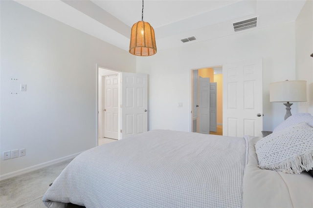 bedroom with light carpet, baseboards, visible vents, and a raised ceiling