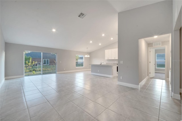 unfurnished living room with light tile patterned floors, a healthy amount of sunlight, and sink