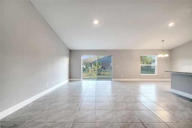 spare room featuring a notable chandelier and light tile patterned floors