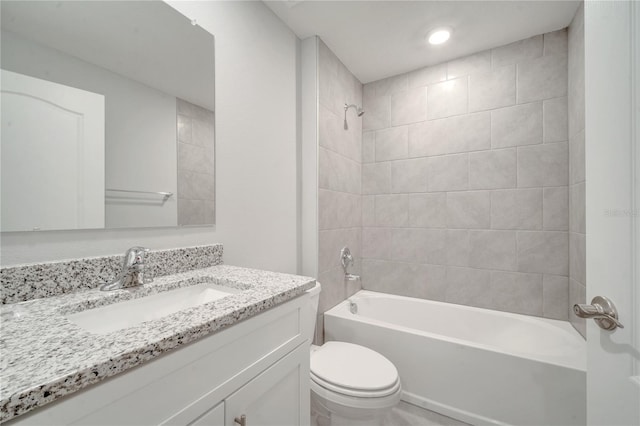 full bathroom featuring vanity, tiled shower / bath combo, and toilet