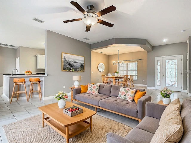 tiled living room with ceiling fan with notable chandelier and sink