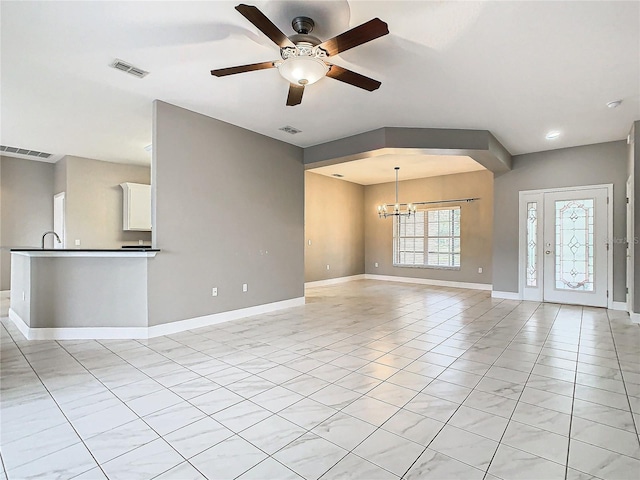 unfurnished living room with ceiling fan with notable chandelier and light tile patterned flooring