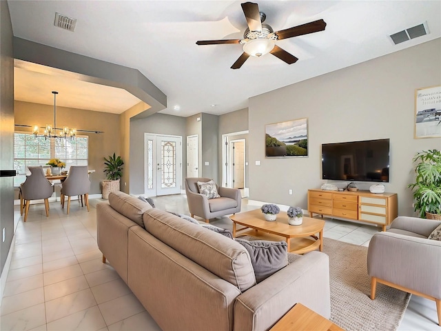 tiled living room featuring ceiling fan with notable chandelier