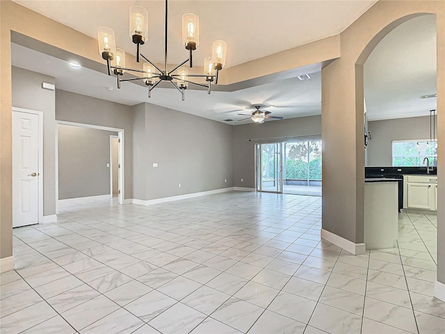 unfurnished room featuring sink and ceiling fan with notable chandelier