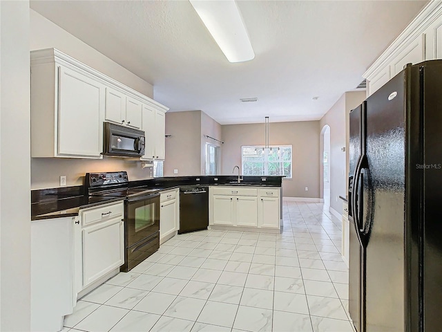 kitchen featuring decorative light fixtures, kitchen peninsula, black appliances, and white cabinets