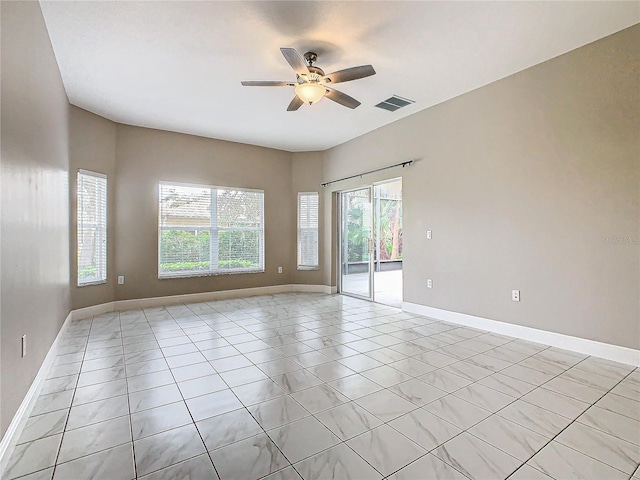 spare room with ceiling fan and light tile patterned floors