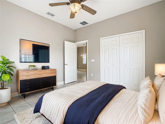 tiled bedroom featuring ceiling fan and a closet